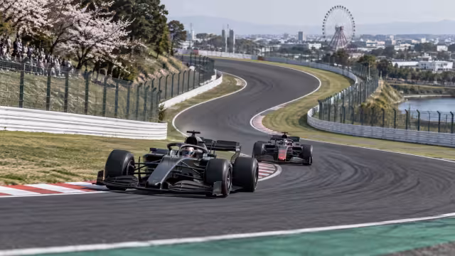 Generovaná ilustrace závodní stopy a vozu na okruhu Suzuka.